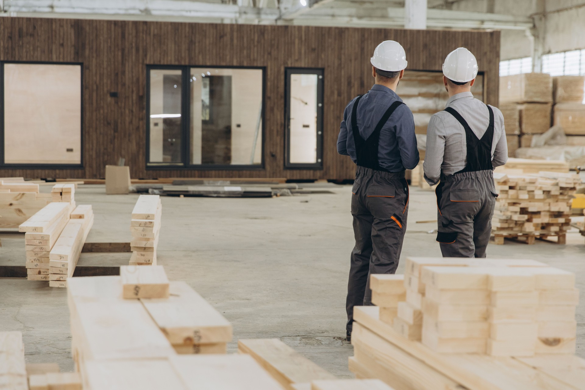 Construction workers inspecting completed modular building in factory