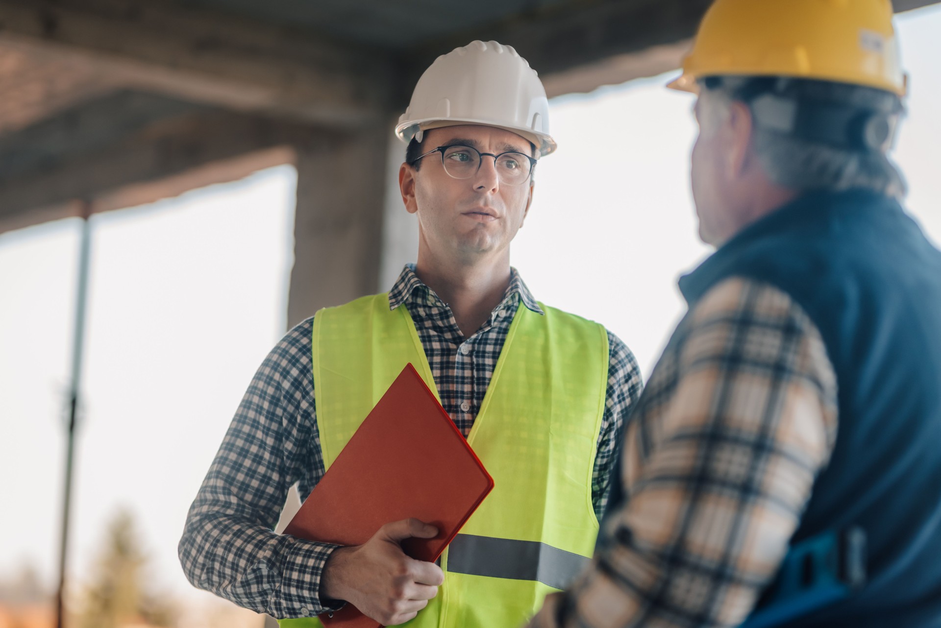 Engineers discussing building project inside unfinished structure